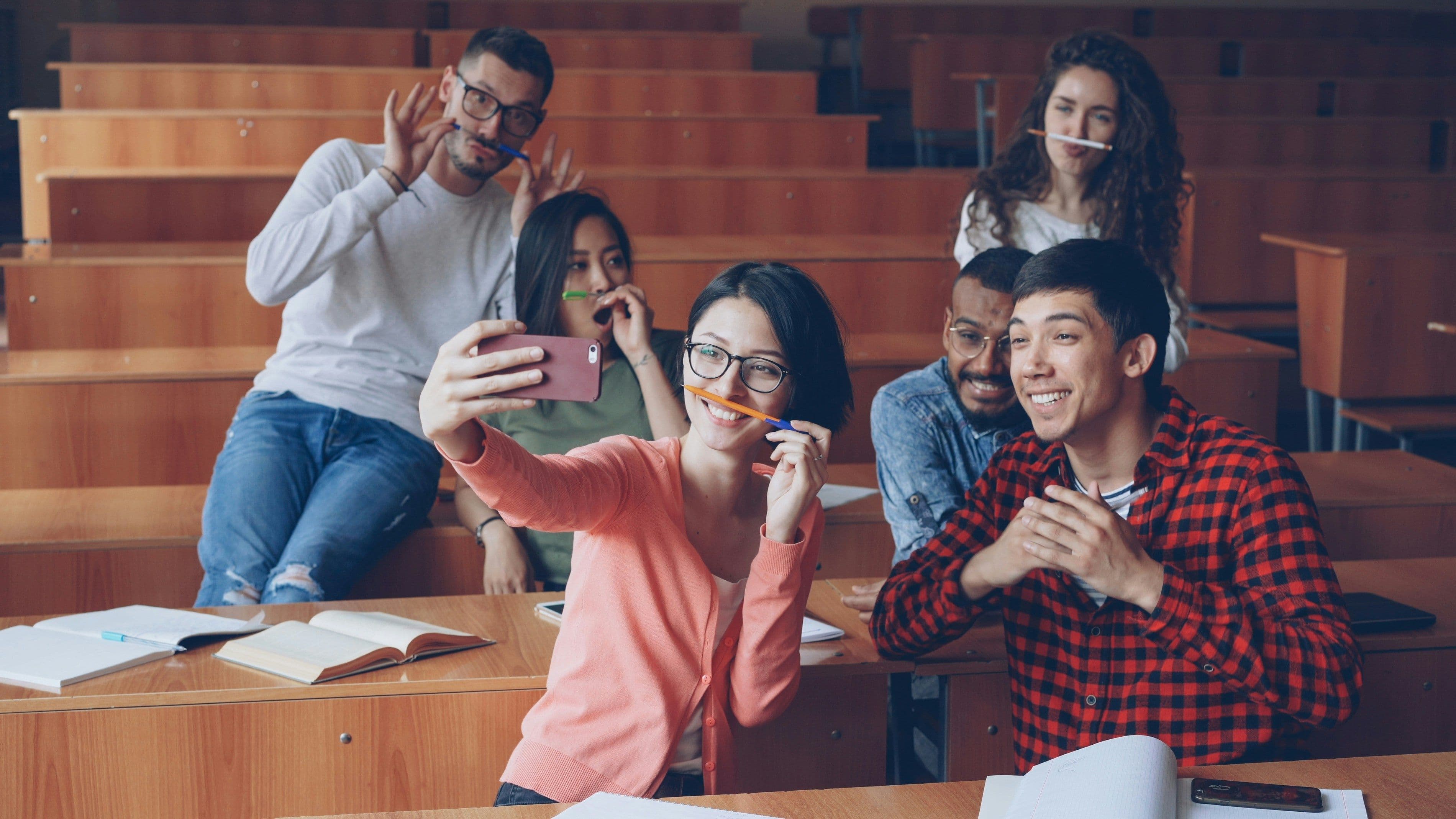 Estudiantes universitarios tomándose una selfie en un salón de clases