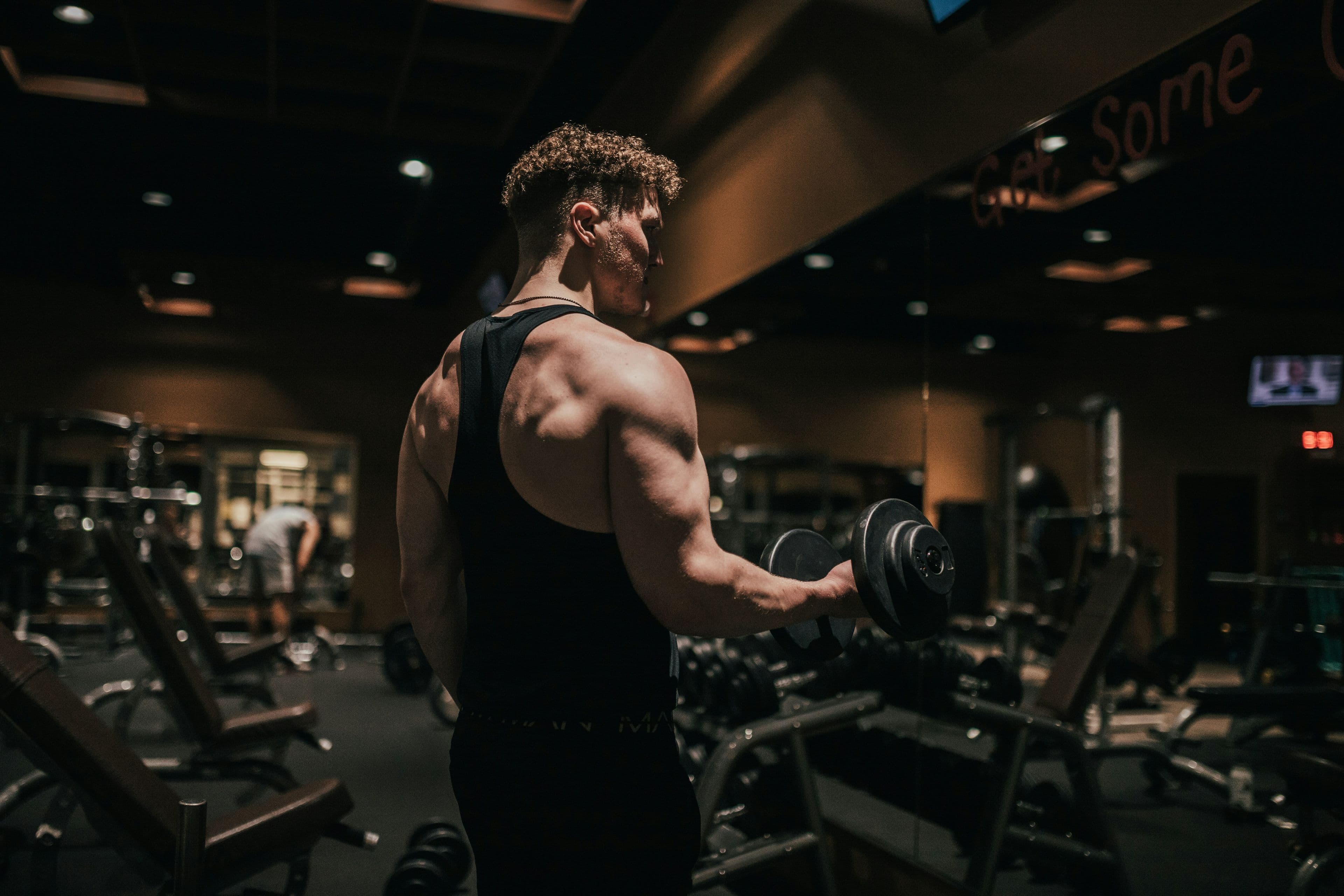 Hombre entrenando con mancuernas en un gimnasio